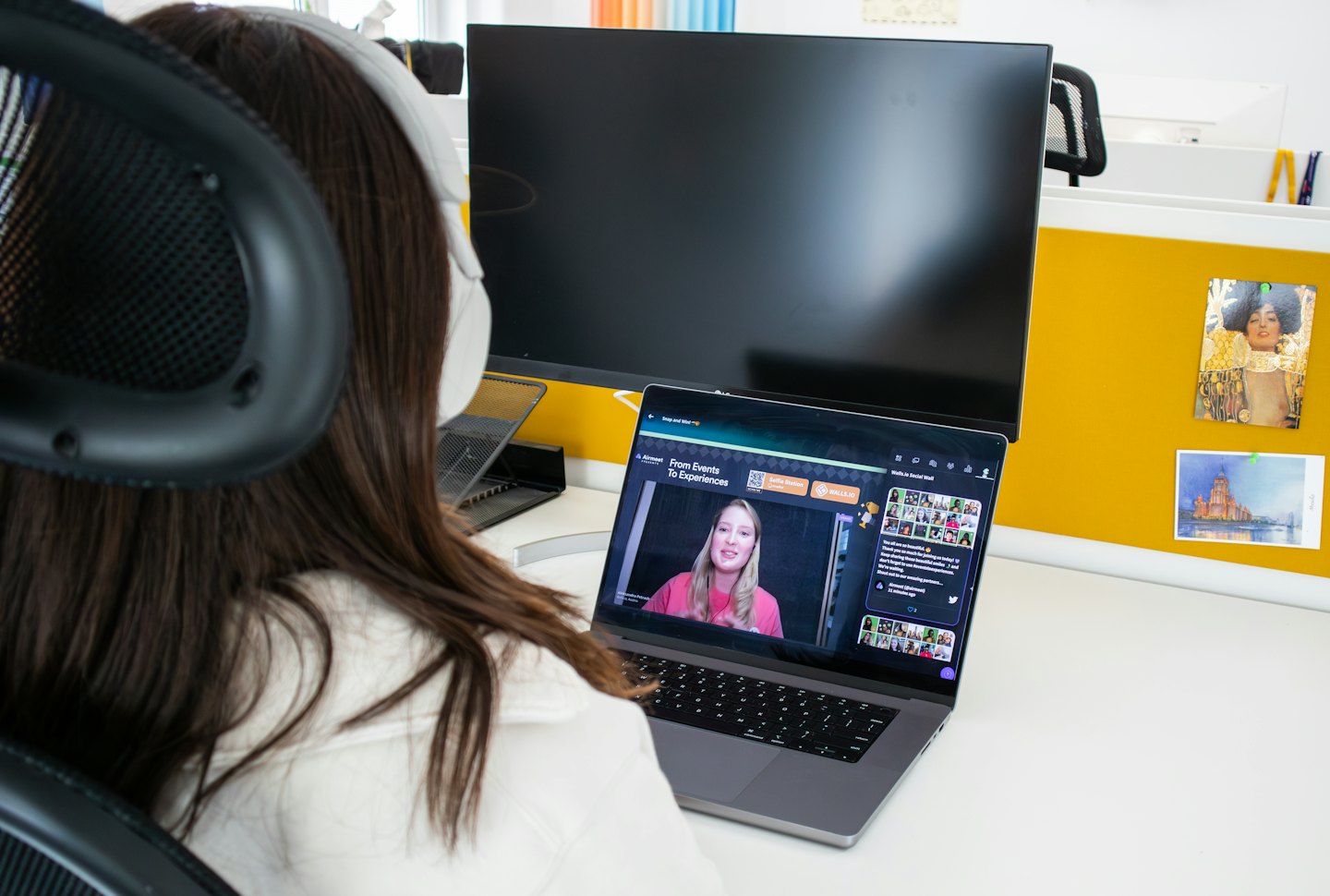Person wearing headphones works at a laptop in a modern office.